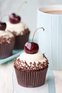 Cupcakes decorated with black cherries and chocolate shavings